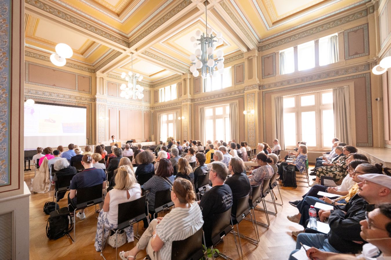Im Raum RAA-G-01 in der Rämistrasse 59 sitzen die Gäste der Veranstaltung und lauschen der Begrüssungsrede von Vizerektorin Gabriele Siegert. Foto: Frank Brüderli